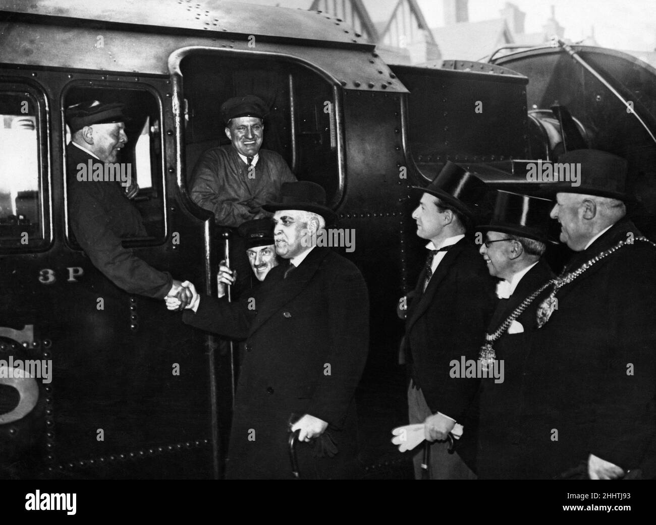 Sir Frederick Stamp, presidente della LM+S Railway, scrolla le mani con Fred Davis, l'autista del motore dell'ultimo viaggio in treno a vapore da Birmingham Park. 15th marzo 1938. Foto Stock