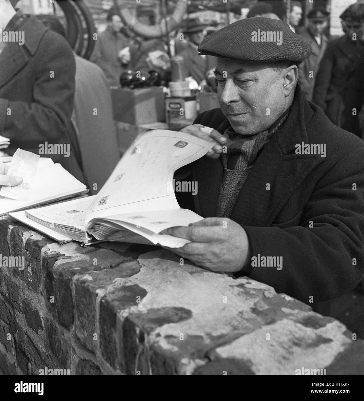 Un collezionista di francobolli che vuole aggiungere alla sua collezione al mercato delle pulci di Club Row, Bethnal Green, E1 Londra 1st marzo 1955 Foto Stock
