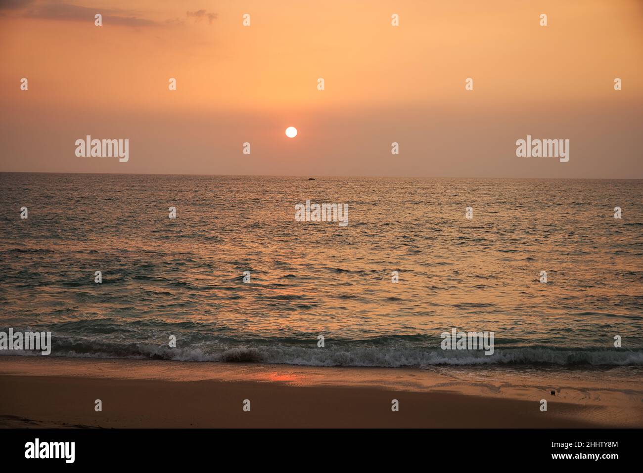 Bellissimo tramonto sulla spiaggia di Khao Lak in Thailandia e si può vedere il ondulato sullo sfondo creando una grande atmosfera romantica. Foto Stock