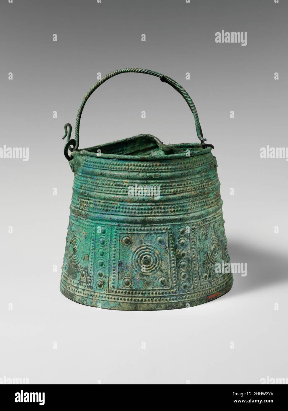 Bronze situla (secchio) 8th secolo a.C. Villanovan la funzione precisa di vasi antichi come questo è sconosciuta. Tuttavia, dal VI secolo a.C., oggetti simili erano rappresentati come vasi da banchetto con vino o qualche altra bevanda che veniva da loro travestita. È interessante notare che i motivi decorativi sulla parte inferiore di questo esempio sono esattamente paralleli su schermi contemporanei in bronzo. Situla di bronzo (secchio) 249233 Foto Stock