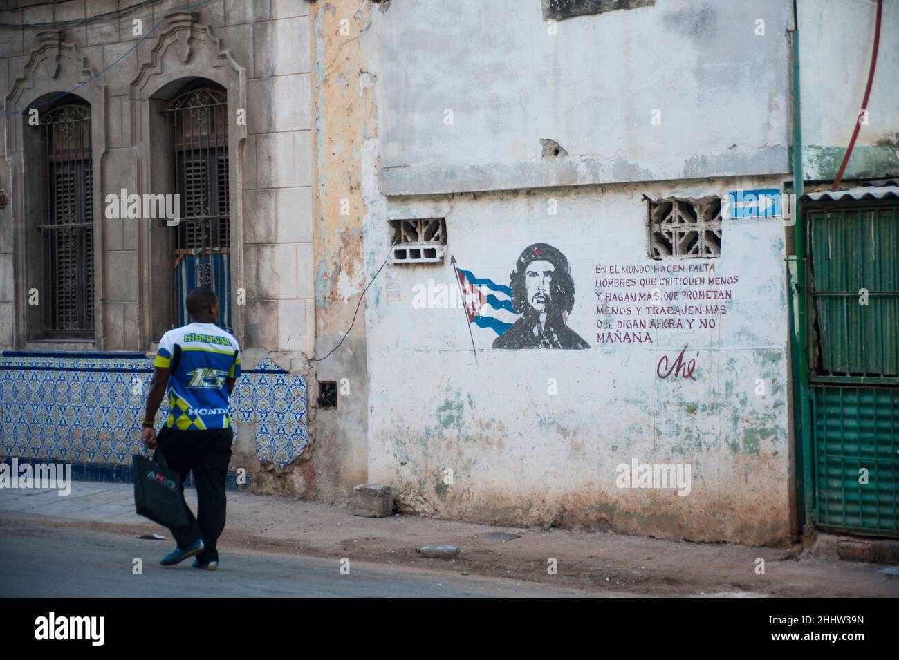 Citazione dal leader della Rivoluzione Cubana che Guevara mentre un uomo cammina oltre tenendo una borsa. Foto Stock