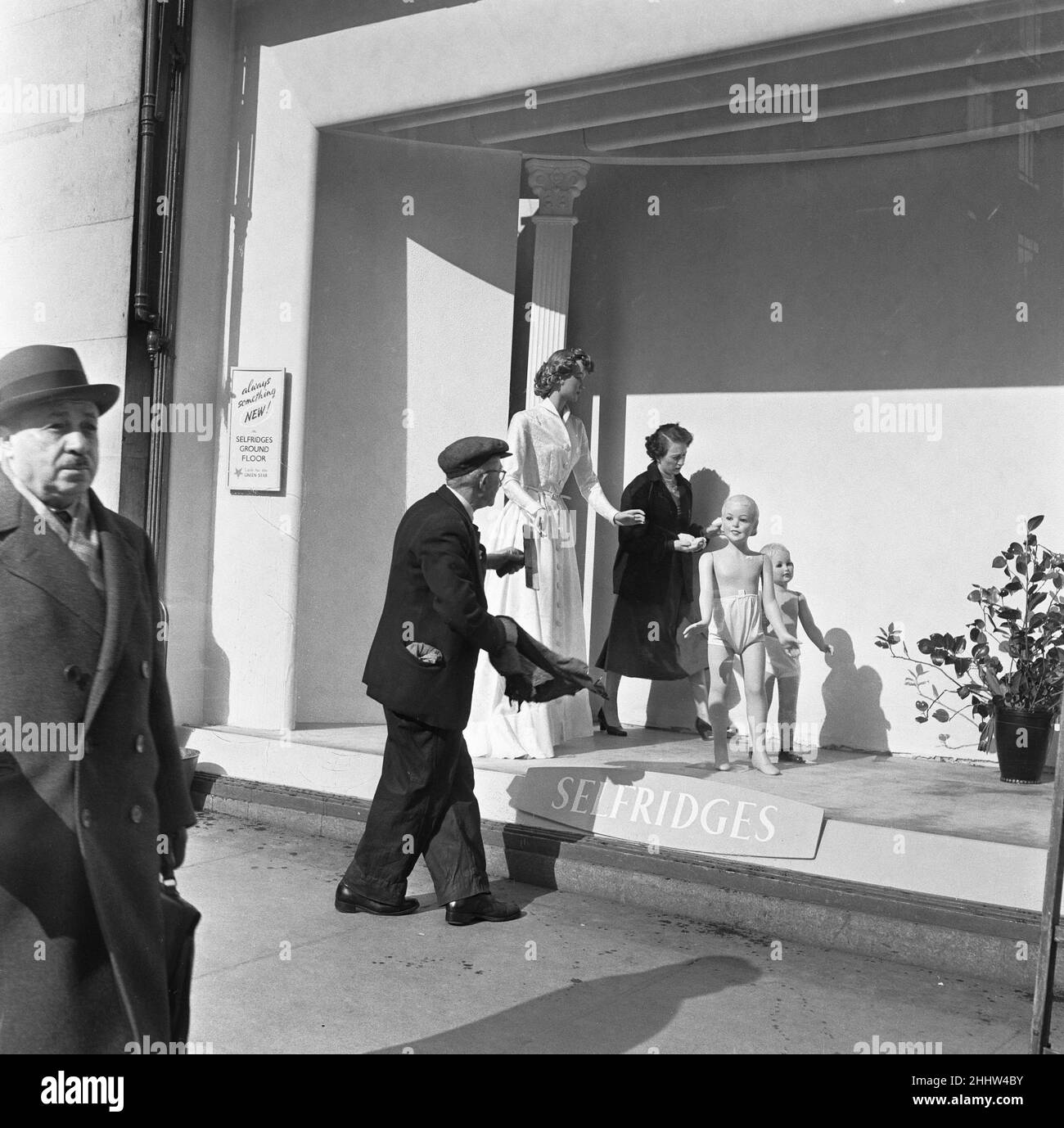 Un dresser della finestra imposta circa il suo compito di creare una scena in una delle finestre del grande magazzino Selfridges sulla Oxford Street di Londra. In questo modo i clienti entreranno nel negozio mentre il detergente per finestre garantisce che gli acquirenti di vetrine possano avere una visione chiara. 8th marzo 1954 Foto Stock