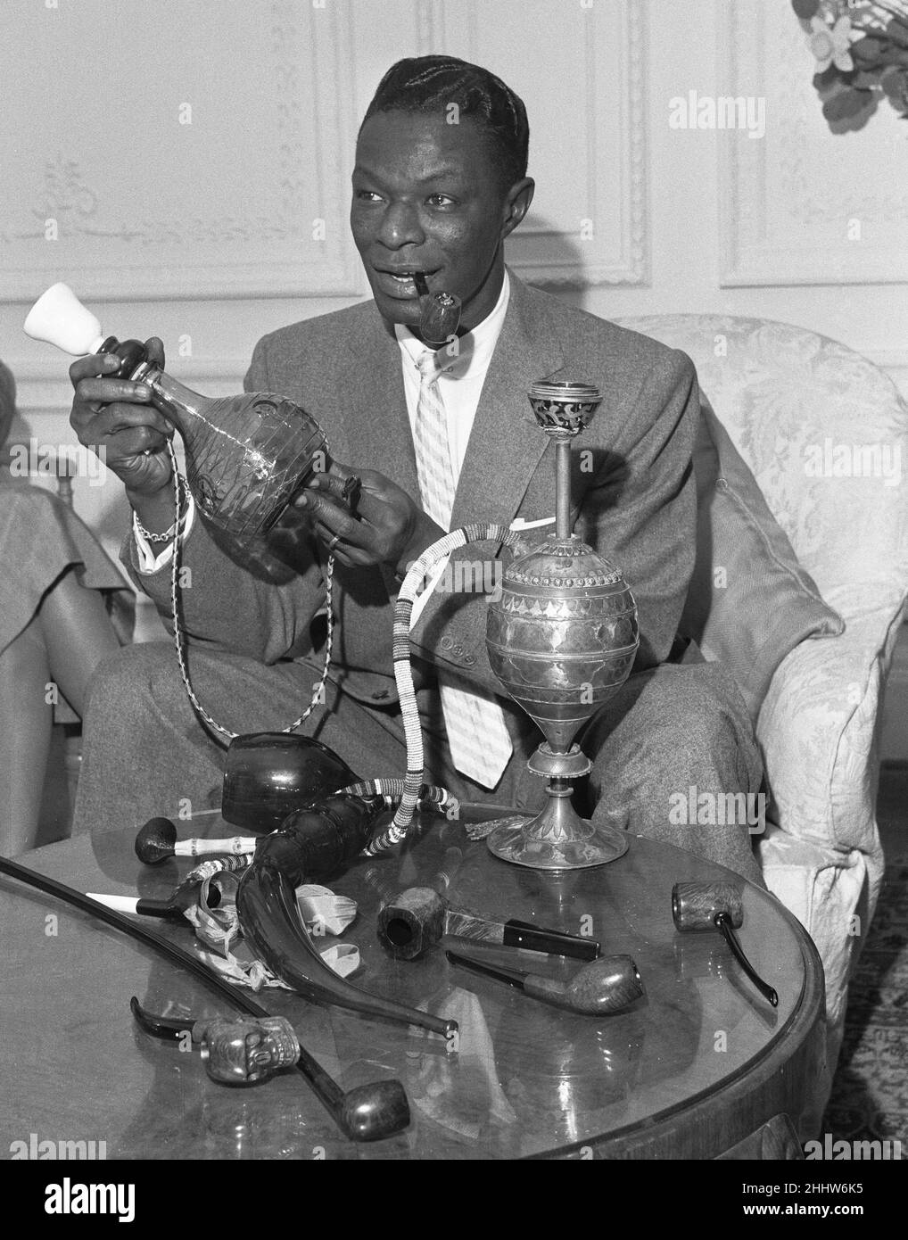 Il cantante e collezionista di tubi Nat King Cole ha visto qui con la sua collezione di tubi nella sua camera d'albergo di Londra. 22nd marzo 1954 Foto Stock