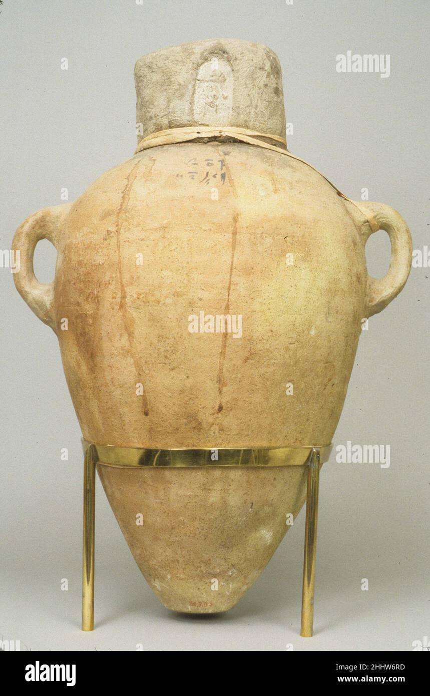 Anfora sigillata contenente olio ca. 1492–1473 a.C. nuovo regno questa anfora ha un'iscrizione in geratico datata all'anno 7 del regno comune di Hatshepsut e Thutmose III. L'iscrizione indica che il vaso contiene due misure di olio di setwy. Il tappo di fango, che copre completamente il collo e la bocca del vaso, è stato stampato con il sigillo di 'Hatshepsut, moglie di Dio di ogni Terra.' Come ulteriore misura di sicurezza, una striscia stretta di tela di lino è stata fatta passare attraverso un manico, avvolta intorno al tappo, e le estremità legate sono state coperte di fango che è stato poi stampato con una guarnizione rettangolare. S Foto Stock