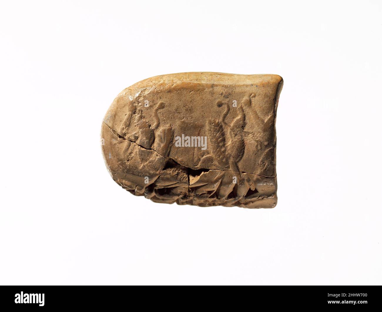 Tavoletta cuneiforme impressa con sigilli: Documento amministrativo inscritto in Achemenid Elamite ca. 500 a.C. Achemenid questa tavoletta di argilla a forma di lingua è rotonda su un lato e diritta sull'altro. Un testo in cuneiforme di Elamite copre gran parte della superficie; le impressioni delle guarnizioni dei cilindri appaiono sul retro e sui lati piatti della compressa. L'impressione sul retro mostra un eroe che tiene una creatura leone alata su entrambi i lati di lui per la sua gamba posteriore. L'impressione sul lato piatto è difficile da fare, ma può mostrare un uomo bearded con i capelli lunghi.il testo di Elamite legge:60 arieti, 75 pecore, 20 OA Foto Stock