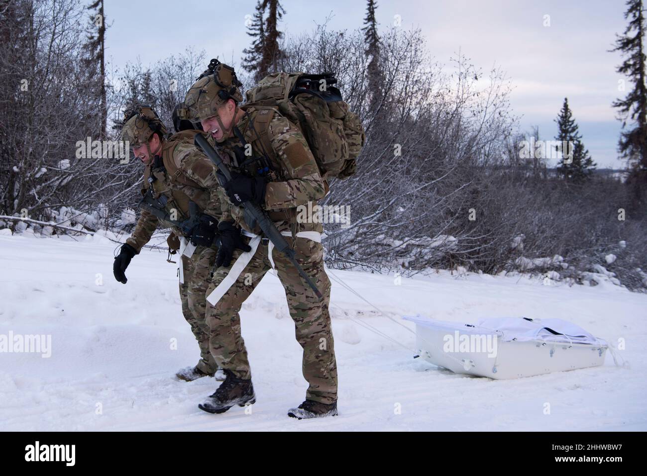 US Air Force Senior Airman Trevor Liggett, a sinistra, E U.S. Air Force Airman 1st Class Christian Dye, entrambi apprendisti Tactical Air Control Party (TACP) assegnati al distaccamento 1, 3rd Air Support Operations Squadron, pratica evacuazioni mediche tirando una slitta pesata durante esercizio POLARE QUAKE alla Joint base Elmendorf-Richardson, Alaska, 12 gennaio 2022. POLAR QUAKE è un esercizio di prova di comando e controllo TACP-run per testare il passaggio dell'intelligenza per trovare, correggere, tracciare, Target, Engage, Processo di valutazione. Conducendo l'esercizio nell'Artico, l'ASOS 3rd costruisce e si infastidisca Foto Stock