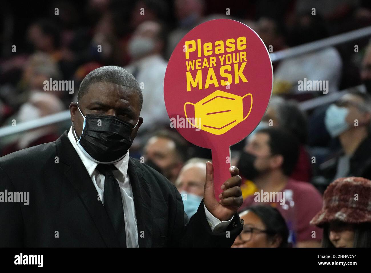 Un usciere tiene in mano un cartello con la scritta "Please wear a (face) mask" durante una partita di basket NCAA tra i Southern California Trojans e gli Arizona State Sun Devils in mezzo all'ondata della variante COVID-19 omicron, lunedì 24 gennaio 2022, a Los Angeles. Foto Stock