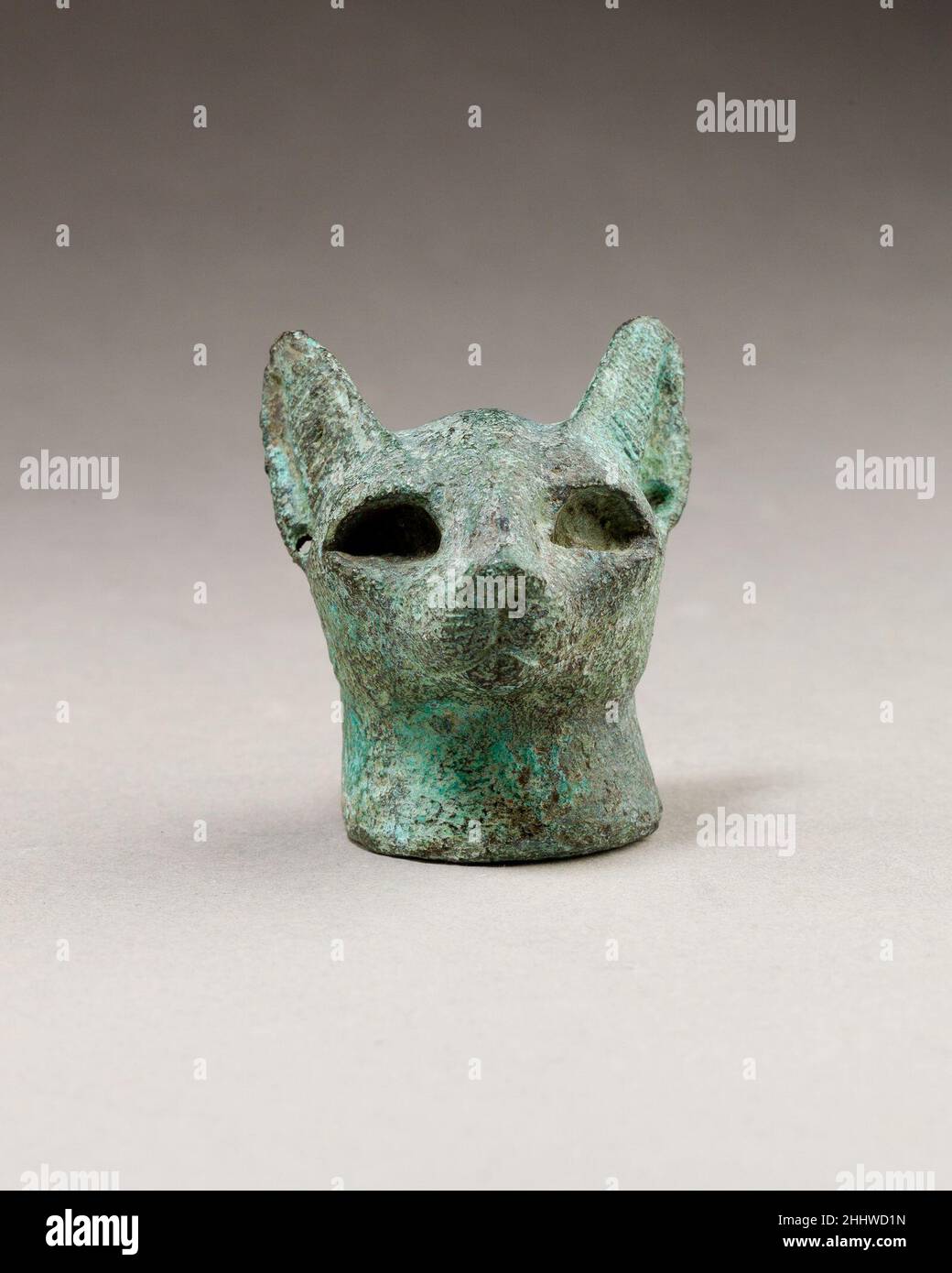 Testa di un gatto 664–30 a.C. periodo tardo-periodo tolemaico il gatto era sacro alla dea Bastet, ed era offerto in santuari e depositato in necropoli animali in tutto l'Egitto. Questo gatto ha una faccia stretta ma grandi occhi profondi per l'aggiunta di inserto. Le linee chiuse e ripetute incise segnano i peli delle orecchie e i baffi sotto il naso. Entrambe le orecchie sono forate e avrebbero avuto orecchini, probabilmente di metallo prezioso.la funzione di queste teste di gatto grandi è ambigua. Sono stati trovati in contesti di offerta, e si assume comunemente che essi formassero parte di una statuetta composita; Th Foto Stock