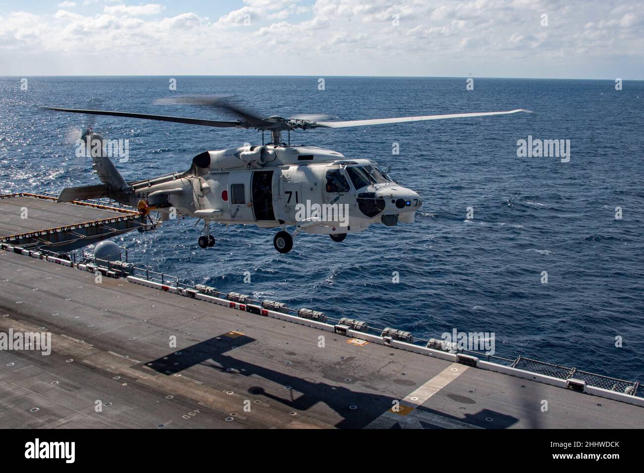 MAR DELLE FILIPPINE (Gen. 21, 2022) un SH-60K Sea Hawk assegnato alla nave della forza di autodifesa marittima giapponese JS Hyuga (DDDH 181) si prepara ad atterrare sul ponte di volo della nave d'assalto anfibio dispiegata in avanti USS America (LHA 6). L'America, nave principale dell'America Amphibious Ready Group, insieme all'unità Marine Expeditionary 31st, sta operando nell'area di responsabilità della flotta USA 7th per migliorare l'interoperabilità con alleati e partner e servire come forza di risposta pronta per difendere la pace e la stabilità nella regione IndoPacifico. (STATI UNITI Foto Navy di Mass Communication Specialist Cole Pursle Foto Stock