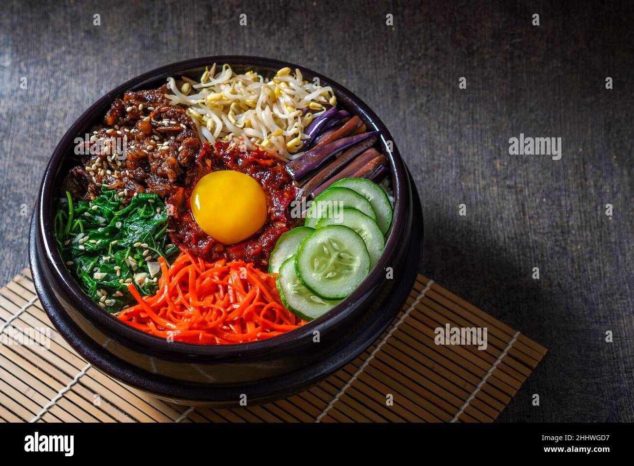 Piatto di riso in stile coreano Bibimbap. Ciotola di riso bianco caldo con bubuggi di manzo, verdure saltate e condite Foto Stock