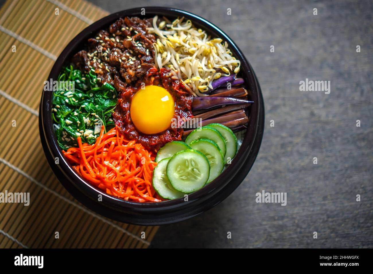 Piatto di riso in stile coreano Bibimbap. Ciotola di riso bianco caldo con bubuggi di manzo, verdure saltate e condite Foto Stock