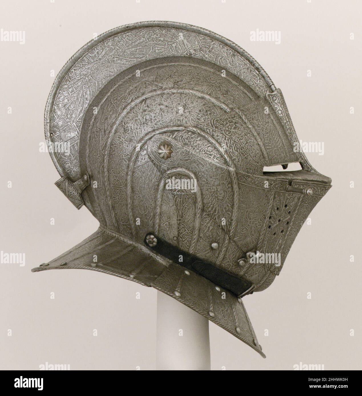 Chiudere il casco per il campo ca. 1600–1610 Francese la decorazione di questo casco, con le sue nervature rialzate che delineano fasce parallele incise con trofei di armi, è tipicamente francese e si trova su un gruppo distintivo di armamenti che risale al regno di Enrico IV (1590–1610). Tra i trofei su questo esempio ci sono cannoni che portano i fleurs-de-lis di Francia. (Lo zoppo del collare anteriore è un restauro moderno.). Chiudere il casco per il campo. Francese. CA. 1600–1610. Acciaio, oro, pelle. Caschi Foto Stock Chiudere il casco per il campo ca. 1600–1610 Francese la decorazione di questo casco, con le sue nervature rialzate che delineano fasce parallele incise con trofei di armi, è tipicamente francese e si trova su un gruppo distintivo di armamenti che risale al regno di Enrico IV (1590–1610). Tra i trofei su questo esempio ci sono cannoni che portano i fleurs-de-lis di Francia. (Lo zoppo del collare anteriore è un restauro moderno.). Chiudere il casco per il campo. Francese. CA. 1600–1610. Acciaio, oro, pelle. Caschi Foto Stock