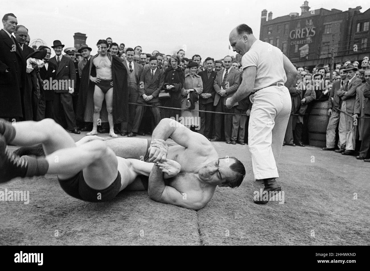 Primo Carnera contro al Hayes, sessione di allenamento all'aria aperta presso i Ludgate Circus Gardens di Londra, un sito di bomba, attira folle a pranzo, Londra, 8th maggio 1952. Si è allenato con al Hayes, il campione di wrestling di pesi massimi britannico, in preparazione al suo prossimo eliminatore del campionato del mondo contro Jack Doyle ad Harringay. Foto Stock