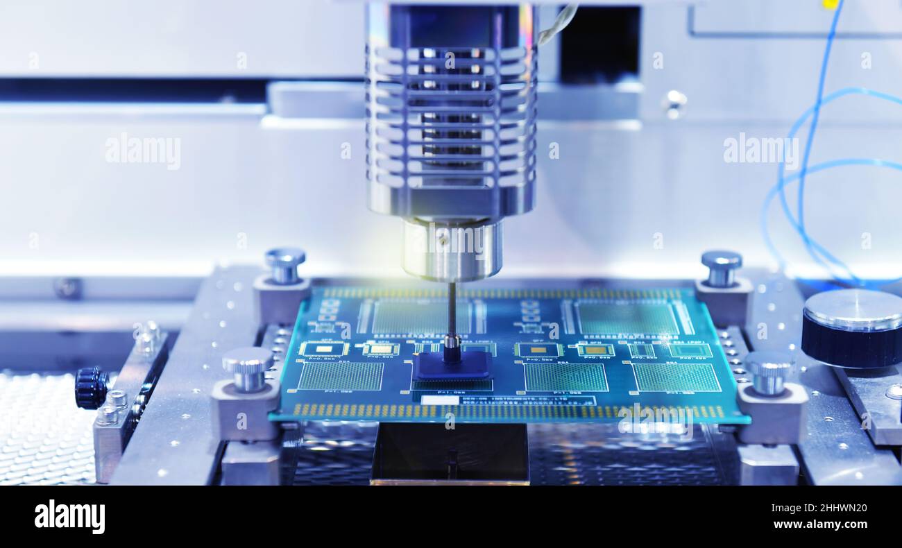 Robot automatico moderno e ad alta tecnologia per la macchina di assemblaggio di schede a circuito stampato (PCB) durante la saldatura o la saldatura di parti o componenti in fabbrica Foto Stock