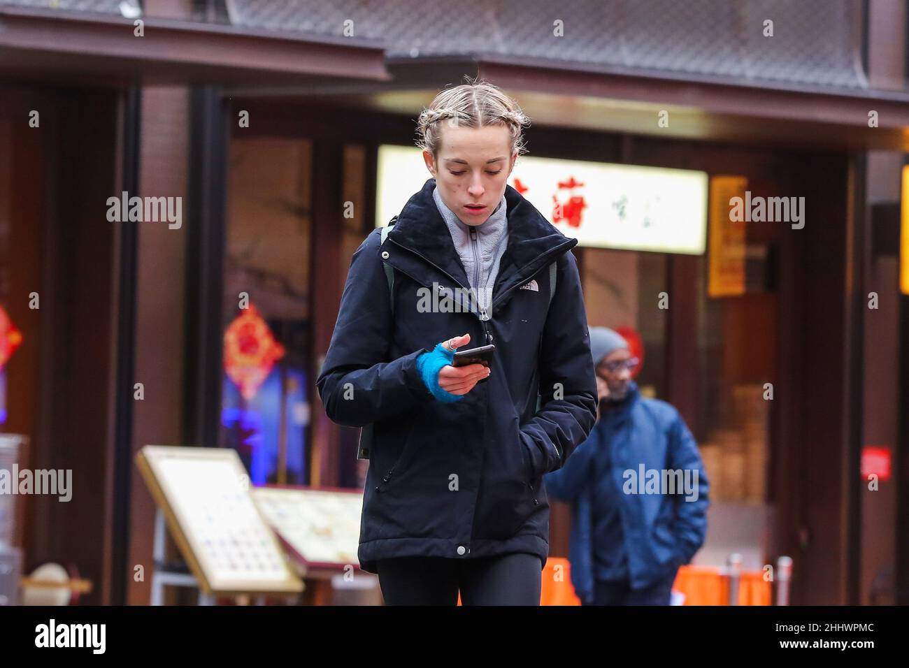 Londra, Regno Unito. 24th Jan 2022. Una donna guarda il suo cellulare mentre cammina a China Town di Londra. (Foto di Dinendra Haria/SOPA Images/Sipa USA) Credit: Sipa USA/Alamy Live News Foto Stock