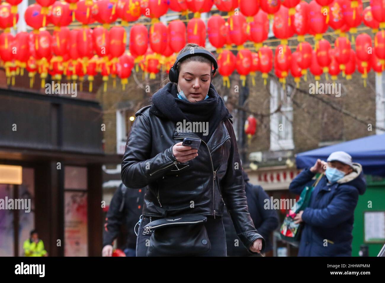 Londra, Regno Unito. 24th Jan 2022. Una donna guarda il suo cellulare mentre cammina a China Town di Londra. (Foto di Dinendra Haria/SOPA Images/Sipa USA) Credit: Sipa USA/Alamy Live News Foto Stock