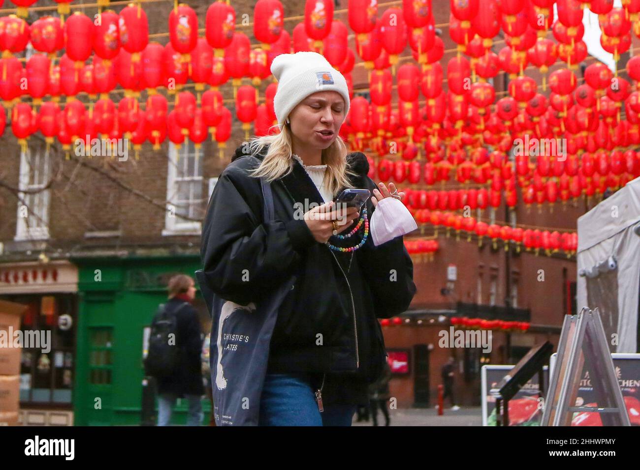 Londra, Regno Unito. 24th Jan 2022. Una donna guarda il suo cellulare mentre cammina a China Town di Londra. (Foto di Dinendra Haria/SOPA Images/Sipa USA) Credit: Sipa USA/Alamy Live News Foto Stock