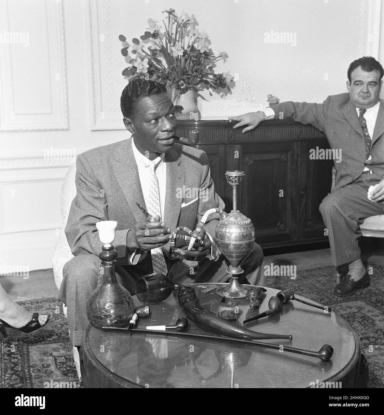 Il cantante e collezionista di tubi Nat King Cole ha visto qui con la sua collezione di tubi nella sua camera d'albergo di Londra. 22nd marzo 1954 Foto Stock