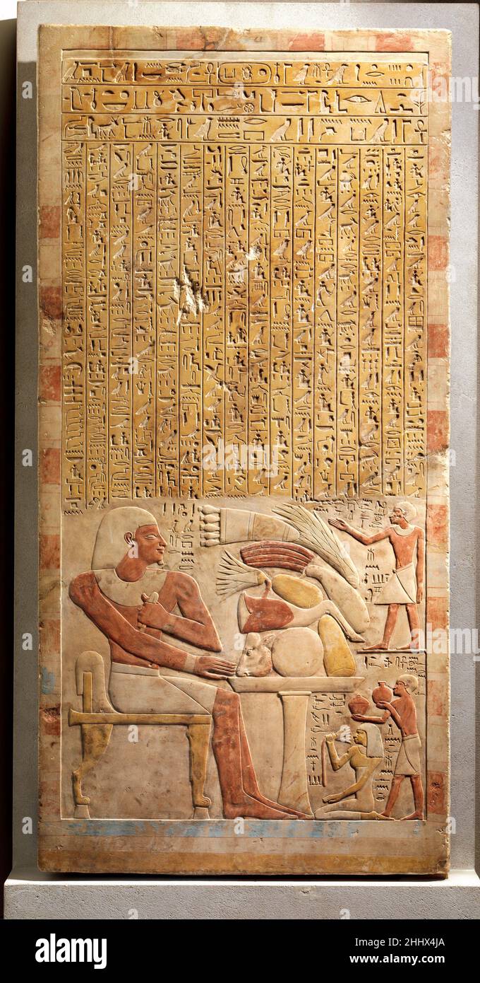 Stela del Steward Mentuwoser ca. 1944 a.C. Regno di mezzo questa stela rettangolare in pietra onora un ufficiale di nome Mentuwoser. Stringendo un pezzo di lino piegato nella sua mano sinistra, si siede al suo banchetto funerario, assicurandosi che riceverà sempre offerte di cibo e che la sua famiglia onorerà e ricorderà per sempre lui. Alla destra di Mentuwoser, suo figlio chiama il suo spirito. Sua figlia tiene un loto, e suo padre offre un piatto coperto di cibo e una brocca che, data la sua forma, contenevano birra. Per mostrare chiaramente ogni tipo di cibo offerto, lo scultore ha disposto le immagini sulla tavola ve Foto Stock