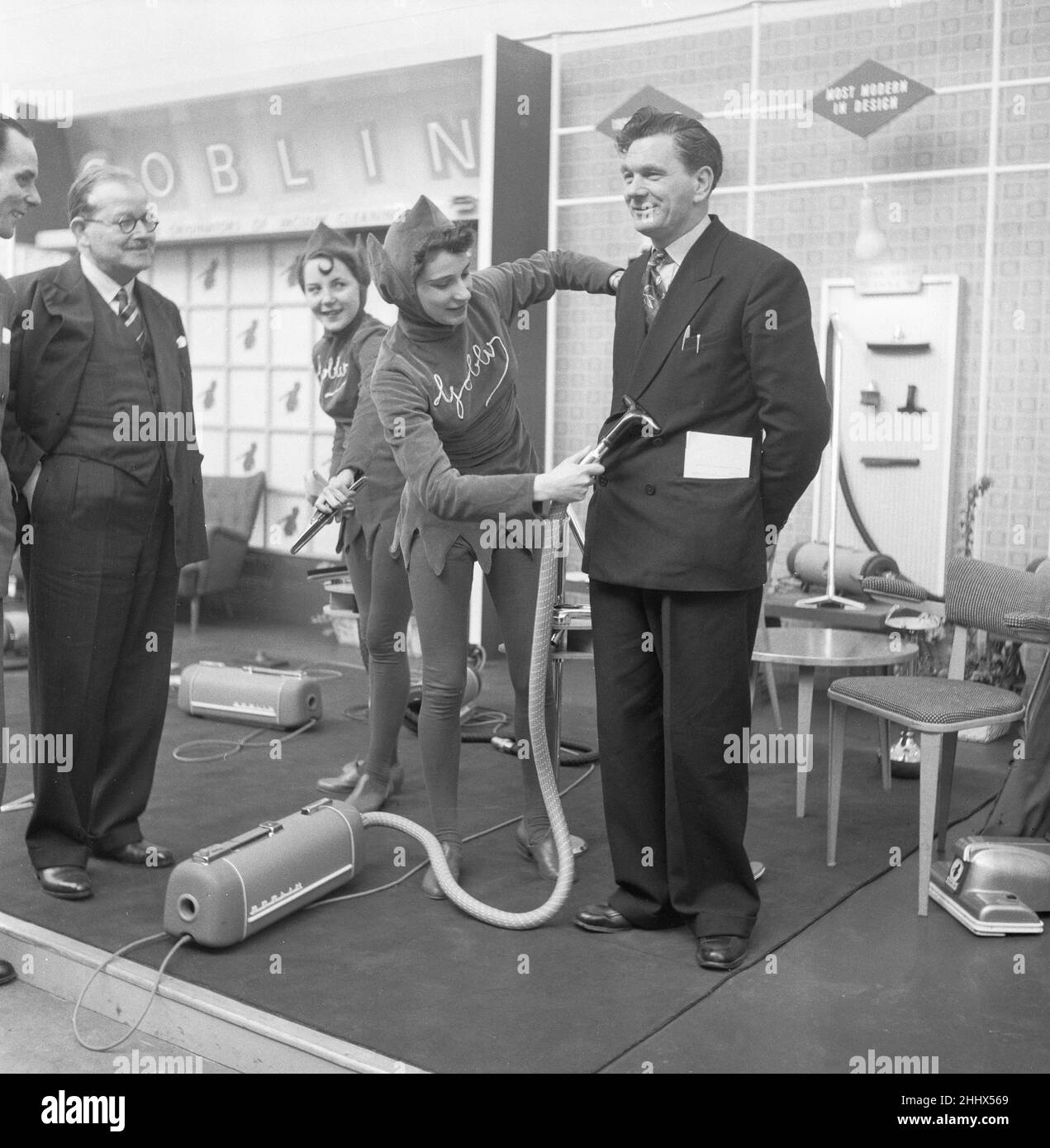 Ideal Home Exhibition Olympia. 3rd marzo 1955A giornalista è agganciato da una donna di vendite vestita come Goblin per dimostrare il potere del nuovo Hoover Goblin vacum pulitore Foto Stock