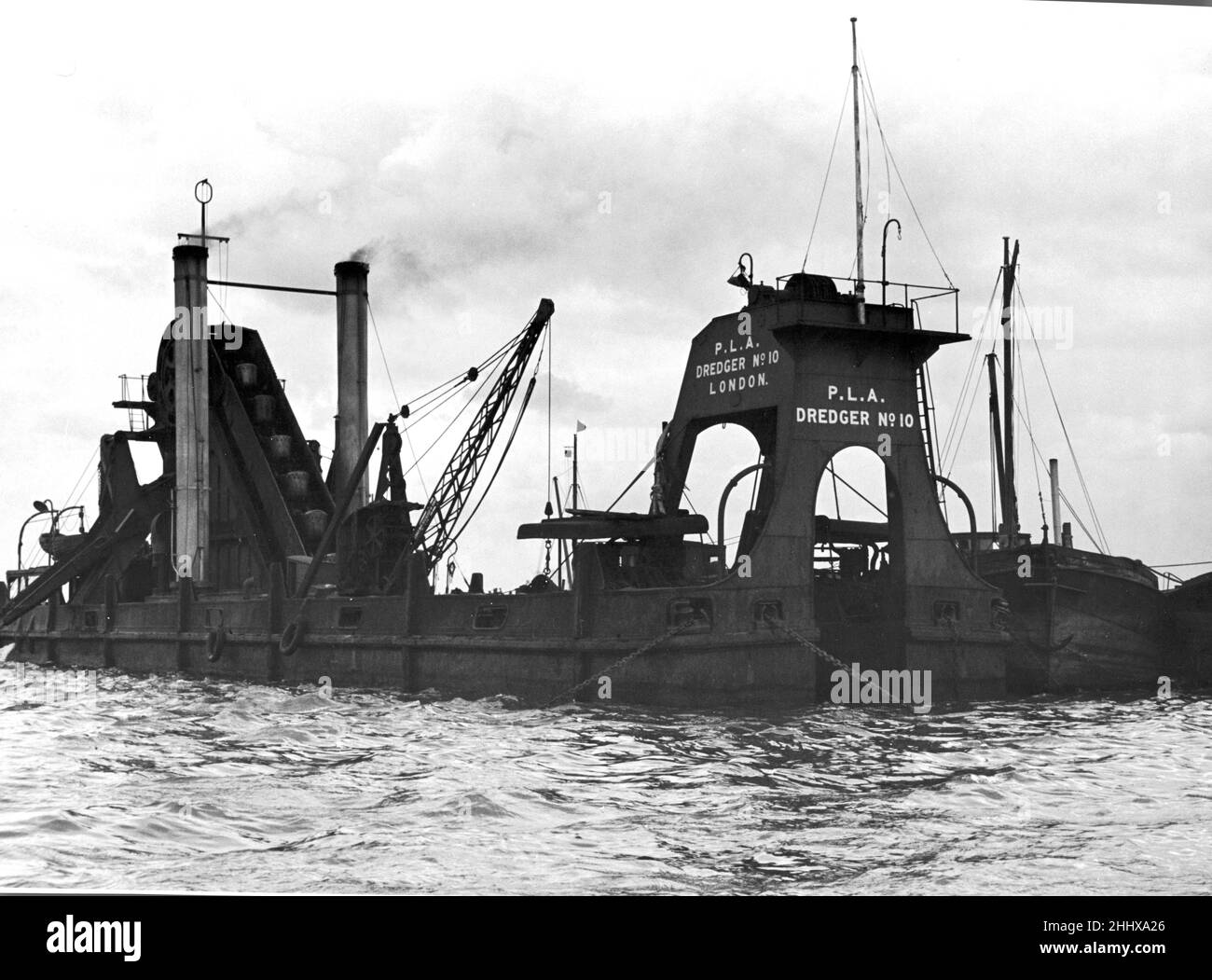 Porto di London Authority Dredger numero 10 con chiatte a fianco al lavoro in acque alte sulle basse rive del Tamigi. Il suo scopo principale è quello di mantenere un canale di navigazione nel Tamigi a una profondità di 40 piedi e 1000 iarde attraverso, riempiendo circa 60 chiatte ogni settimana con circa 6000 iarde cubiche di zavorra. 27th aprile 1949. Foto Stock