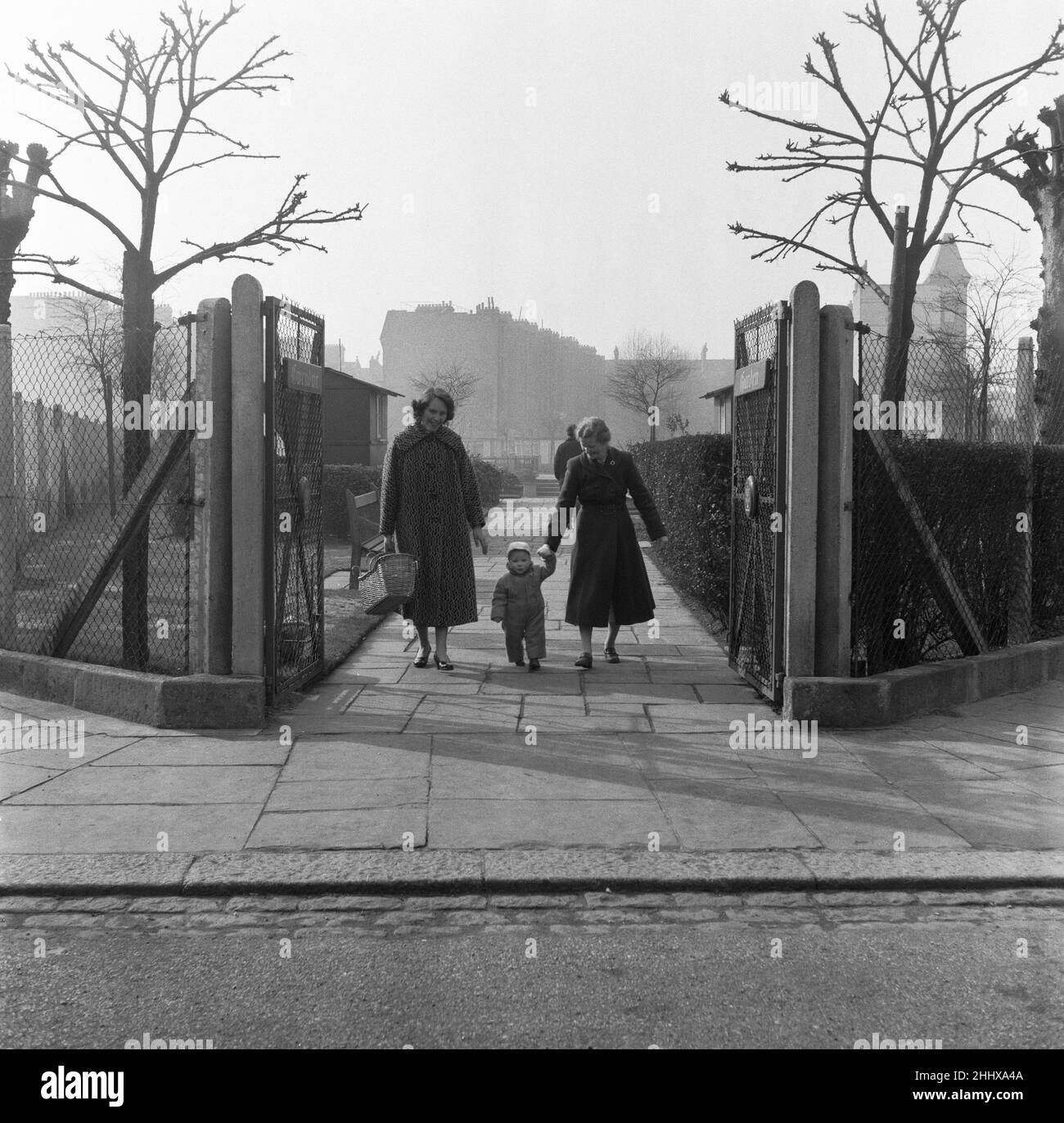 Madre, nonna e bambino sono stati visti qui a piedi in un East London Park senza nome. 3rd marzo 1955. Foto Stock