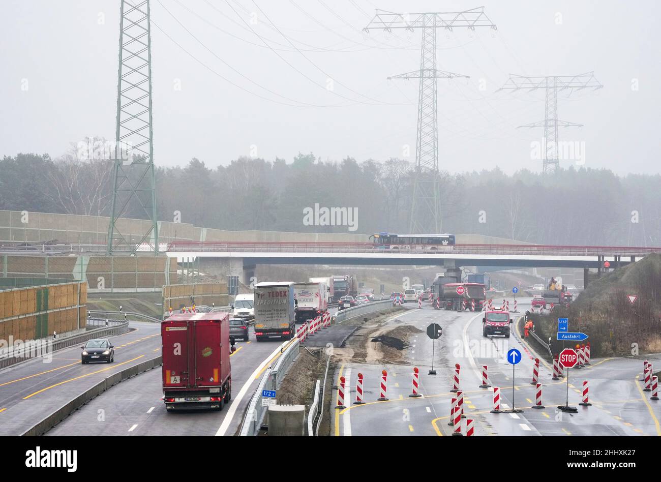 Birkenwerder, Germania. 25th Jan 2022. Auto e camion guidare all'uscita Birkenwerder in pioggia e nebbia leggera sulla superstrada A10 sotto il ponte di nuova costruzione della strada a B96 tronco. La sezione tra lo svincolo di Oranienburg e l'uscita di Mühlenbeck è attualmente al centro dei lavori di costruzione nei pressi di Birkenwerder. Il più grande progetto stradale federale di Brandeburgo è in fase di implementazione da parte dell'appaltatore privato Havellandautobahn GmbH durante il traffico in corso. Credit: Soeren Stache/dpa-Zentralbild/dpa/Alamy Live News Foto Stock