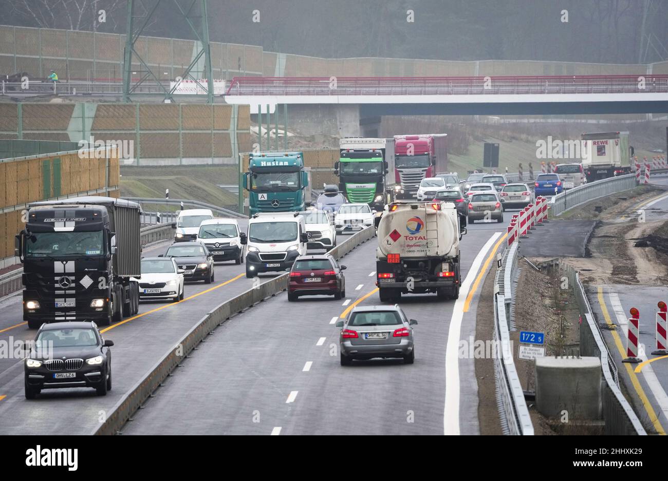 Birkenwerder, Germania. 25th Jan 2022. Auto e camion guidare all'uscita Birkenwerder in pioggia e nebbia leggera sulla superstrada A10 sotto il ponte di nuova costruzione della strada a B96 tronco. La sezione tra lo svincolo di Oranienburg e l'uscita di Mühlenbeck è attualmente al centro dei lavori di costruzione nei pressi di Birkenwerder. Il più grande progetto stradale federale di Brandeburgo è in fase di implementazione da parte dell'appaltatore privato Havellandautobahn GmbH durante il traffico in corso. Credit: Soeren Stache/dpa-Zentralbild/dpa/Alamy Live News Foto Stock