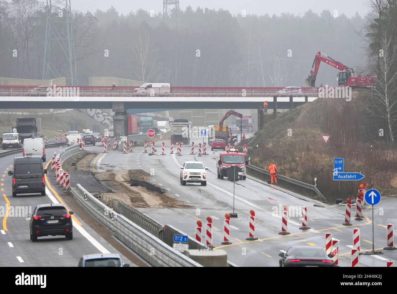 Birkenwerder, Germania. 25th Jan 2022. Auto e camion guidare all'uscita Birkenwerder in pioggia e nebbia leggera sulla superstrada A10 sotto il ponte di nuova costruzione della strada a B96 tronco. La sezione tra lo svincolo di Oranienburg e l'uscita di Mühlenbeck è attualmente al centro dei lavori di costruzione nei pressi di Birkenwerder. Il più grande progetto stradale federale di Brandeburgo è in fase di implementazione da parte dell'appaltatore privato Havellandautobahn GmbH durante il traffico in corso. Credit: Soeren Stache/dpa-Zentralbild/ZB/dpa/Alamy Live News Foto Stock