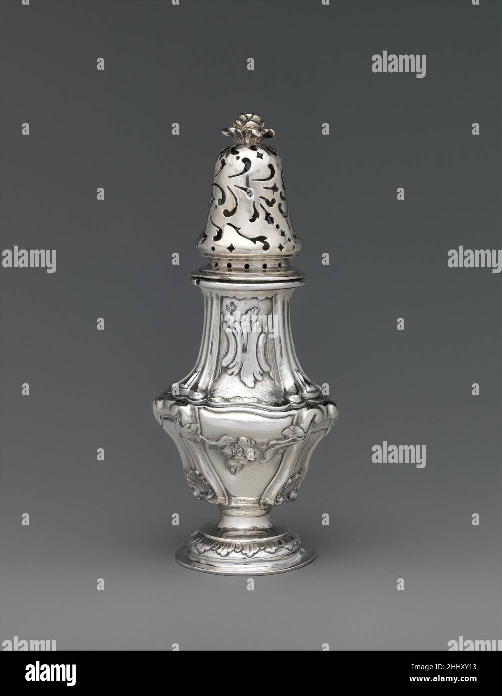 Ruota ca. 1765 Josephus Pasperger i Sugar era una merce rara nel XVIII secolo e spesso circondata da cerimonia. La colata dello zucchero, secondo il n. 2010.110.59a, b, con il suo coperchio forato a cupola, forma un accoppiamento con la pentola di senape, 2010.110.60, con il suo coperchio incernierato ed una fessura per una siviera. Set come questo erano molto rari nel continente europeo, il che può indicare che l'orafo o patrono era familiare con l'argento inglese, dove questi tipi erano più comuni. L'architettura barocca italiana e austriaca ispirò chiaramente il potente profilo di questa nave. I bracci incisi r Foto Stock