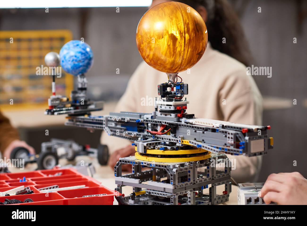 Primo piano dei bambini che proiettano robot dai dettagli del costruttore presso la scuola di scienza Foto Stock