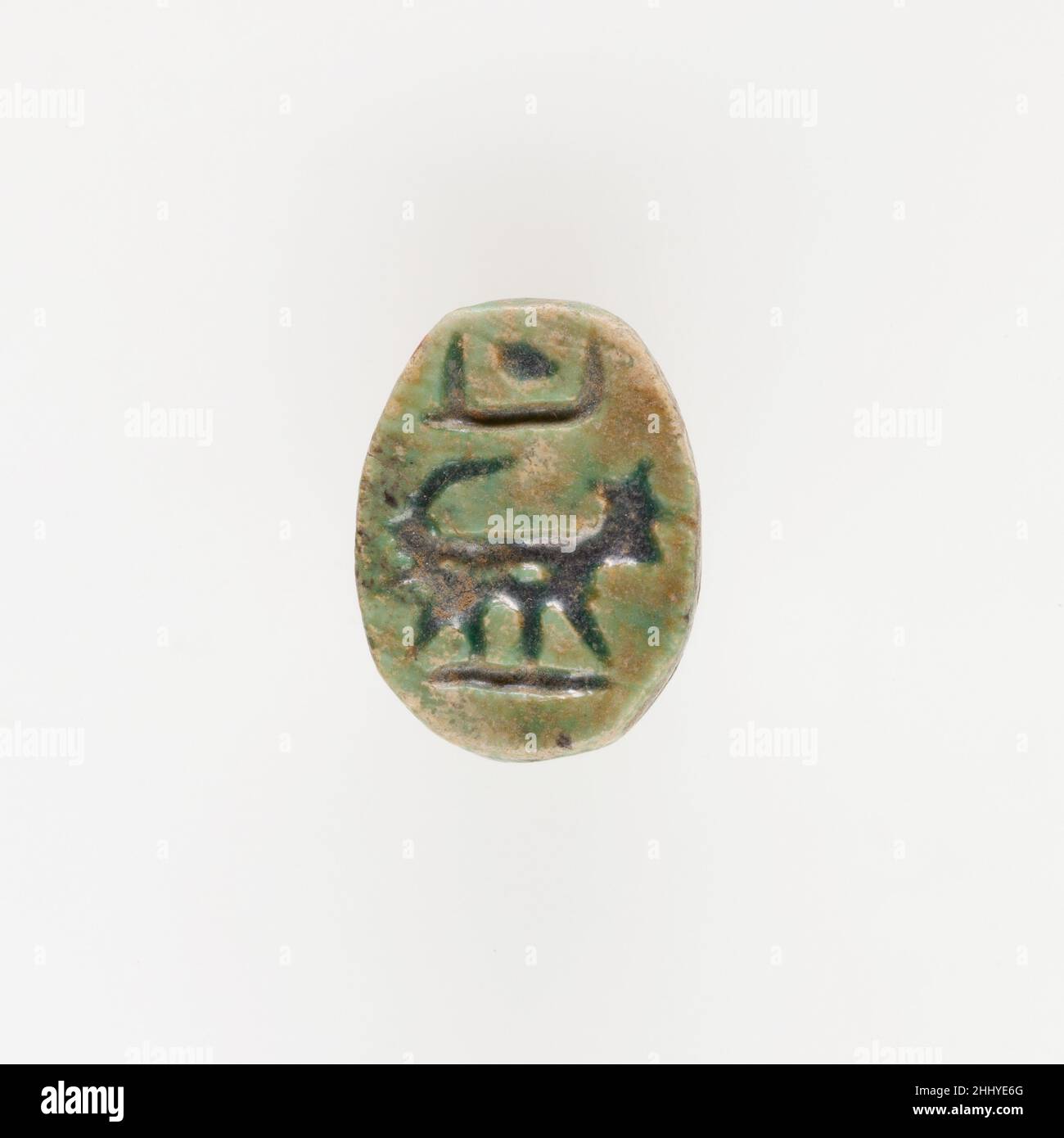 Scarabeo con quadruplicato ca. 1186–945 a.C. nuovo regno – terzo periodo intermedio la parte inferiore di questo scarabeo mostra una marcia quadruplicata a destra, con un simbolo solare sopra la schiena. Se da un lato le caratteristiche dell’animale non sono abbastanza chiare da identificarlo con certezza, dall’altro la lunga coda arricciata verso l’alto e le orecchie prominenti lo rendono molto probabilmente un leone. Questa interpretazione è supportata dal fatto che, nell'antico Egitto, i leoni e le divinità leonine erano spesso associati alla potenza del sole (il dio Re), a cui si fa riferimento nel disco solare posto in cima. Scarabeo con quadruplicato 545254 Foto Stock