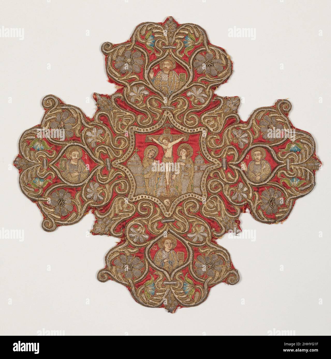 Croce ricamata da un Omoforion fine 17th o inizio 18th ottomano formato come spruzzi di ornamento floreale, questa croce ricamata da una stola esterna del vescovo, o omoforion, riflette la diffusione verso est dello stile barocco via Venezia. Questa croce ricamata e la sua coppia (vedi 17.120.107) raffigurano la Crocifissione di Cristo e la Pentecoste, circondate, rispettivamente, dagli scrittori dei Vangeli e dai quattro profeti. Croce ricamata da Omoforion 219960 Foto Stock