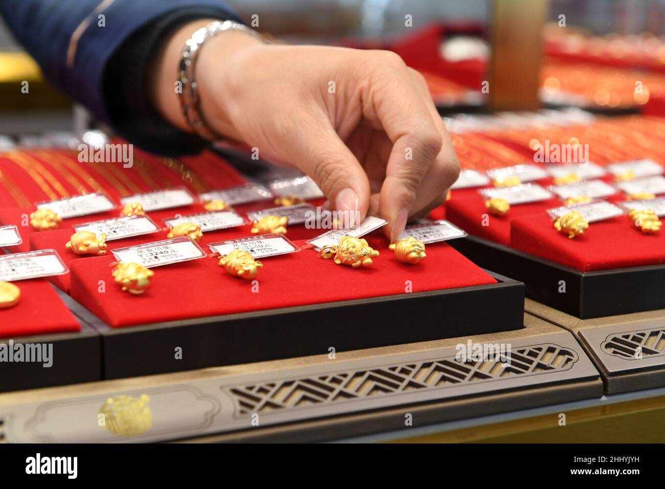 RENHUAI, CINA - 26 GENNAIO 2022 - Un membro dello staff mostra gioielli d'oro dello zodiaco cinese nell'anno della Tigre in un negozio nella città di Renhuai, Sud Foto Stock