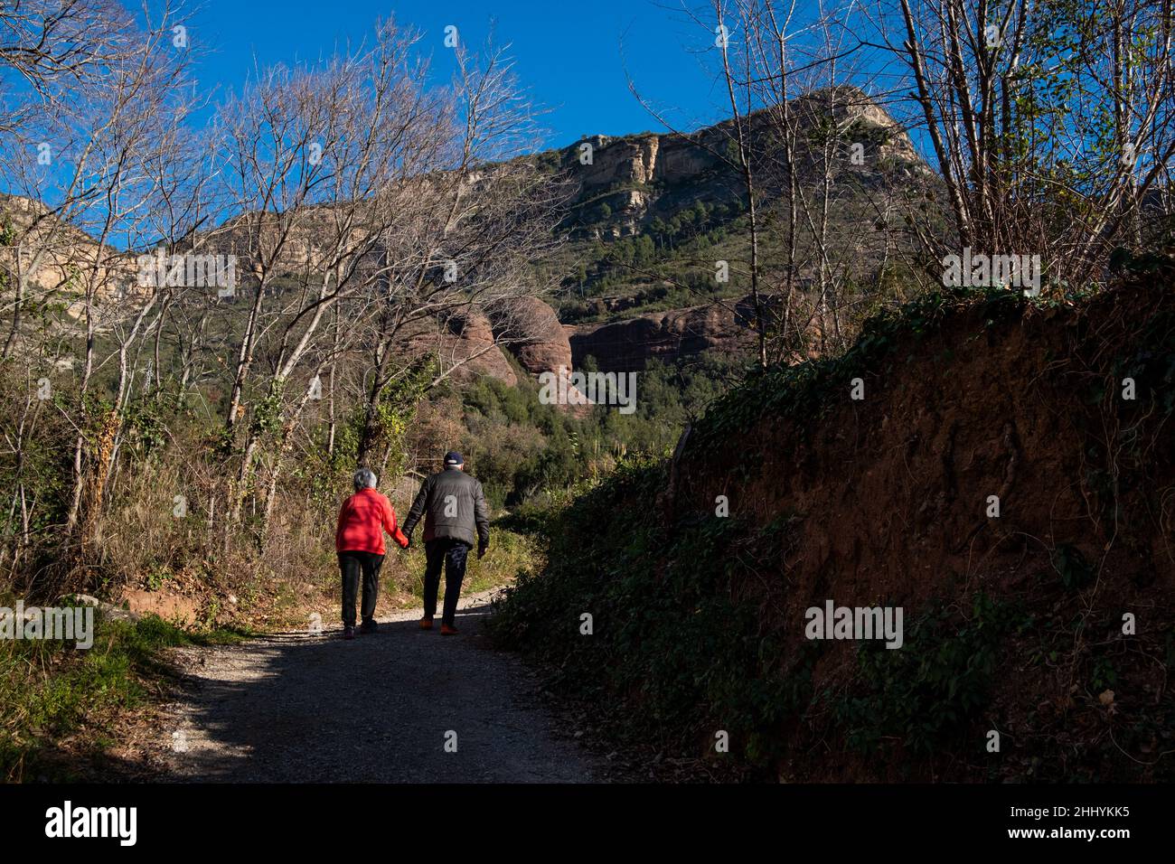 Coppie anziane passeggiate all'aperto trekking nel paesaggio catalano montagne e prati a Sant Miquel del Fai nella campagna della Catalogna. Catalano rurale Foto Stock