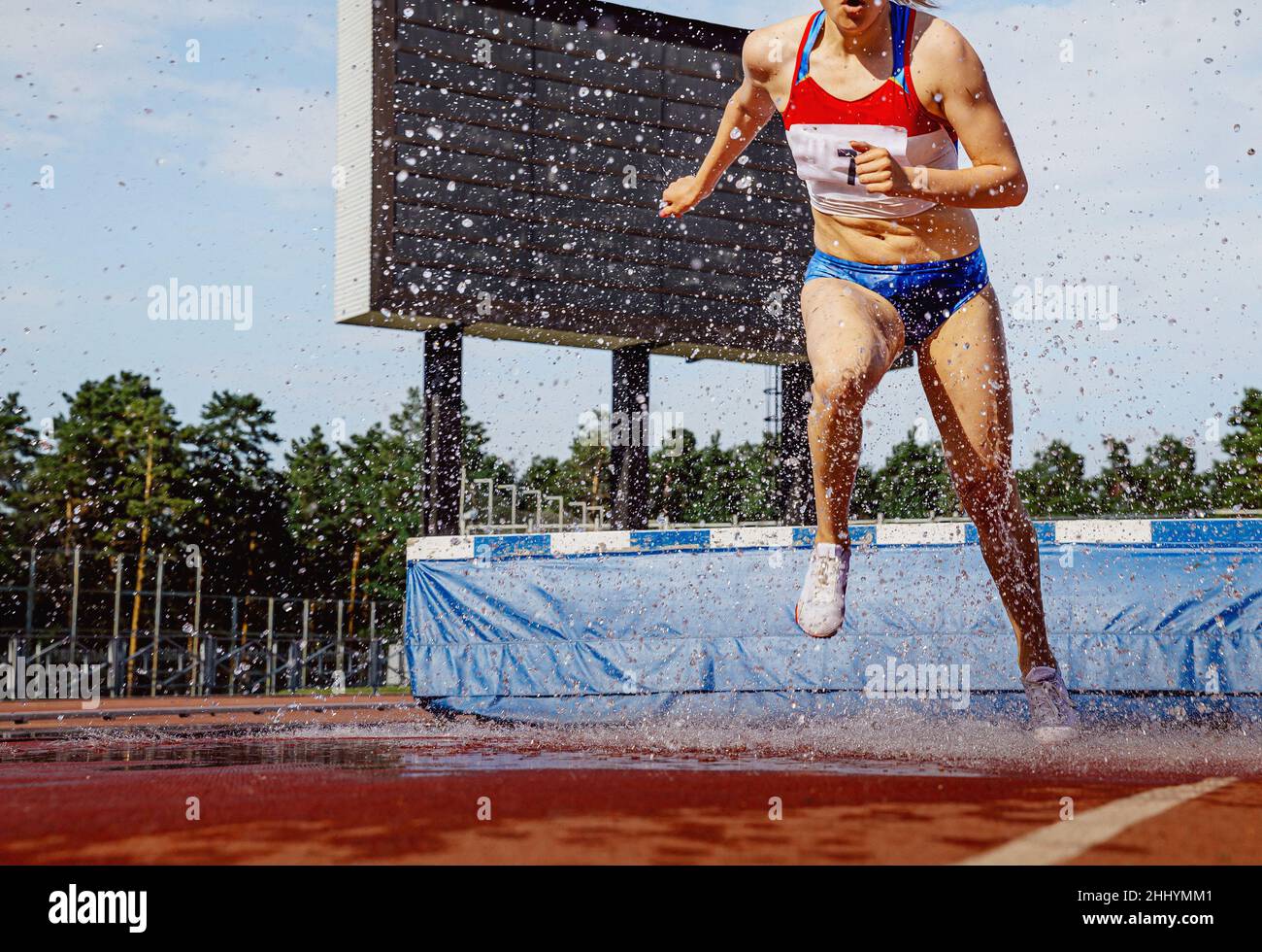 atleta femminile che corre steeplechase in competizione atletica Foto Stock