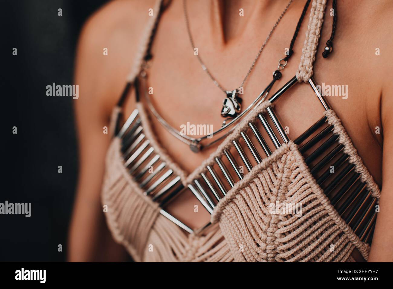 Parte di un corpo femminile vestito da un elegante top in boho beige con dettagli in argento. Moda donna e accessori Foto Stock