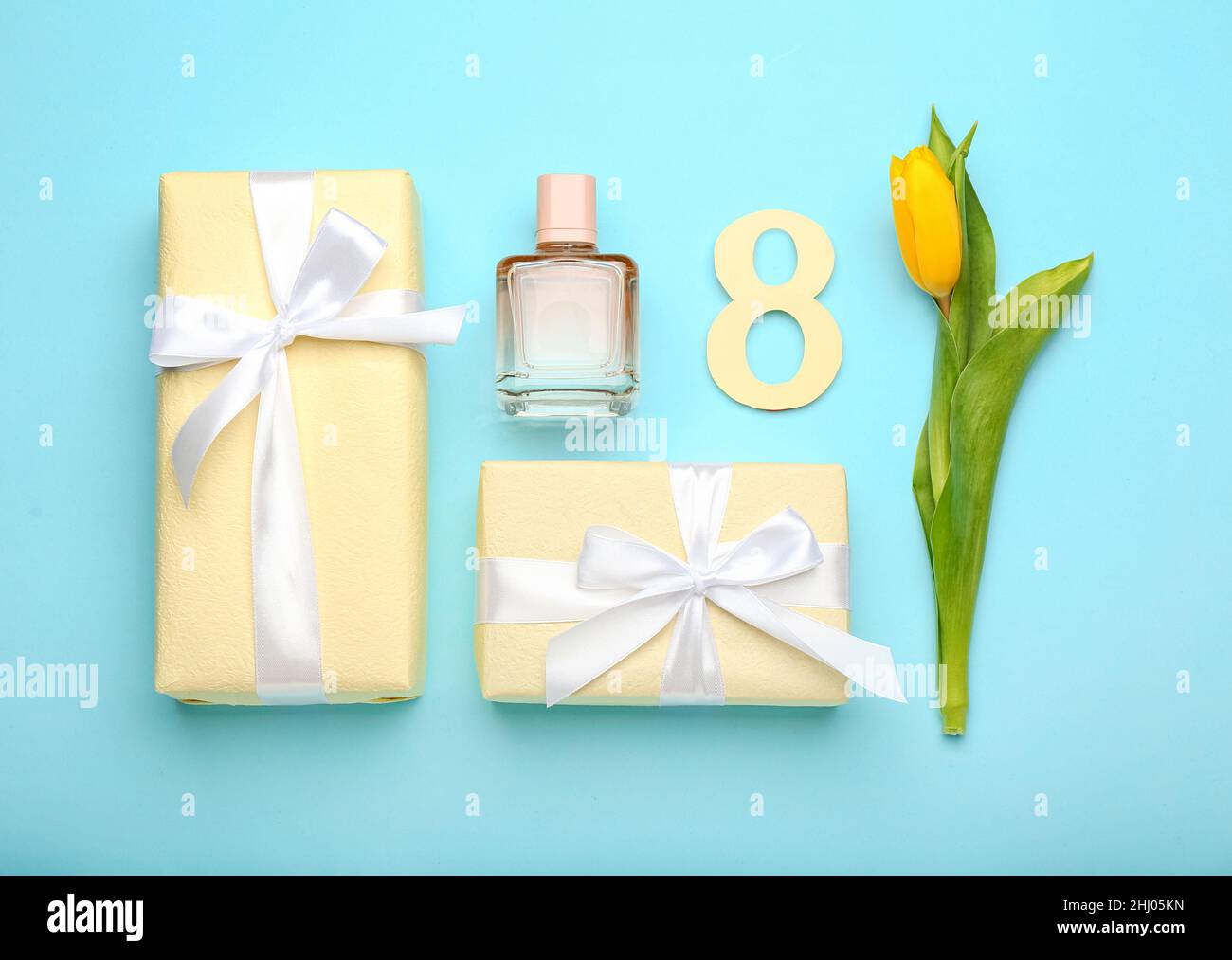 Composizione con figura 8, confezioni regalo, bottiglia di profumo e tulipano per la celebrazione della Giornata Internazionale della Donna su sfondo colorato Foto Stock
