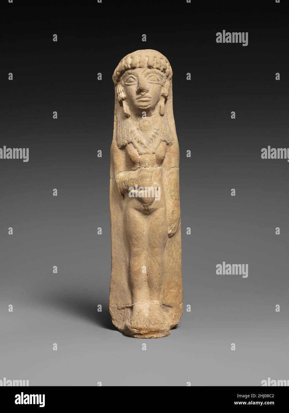 Terracotta donna ca. 600–480 a.C. Cipriota questa figura e 74.51.1579 sono associate al culto di Astarte, la dea della fertilità del Vicino Oriente, a Cipro. Una sacerdotessa o un votario, la donna indossa un indumento sottile e gioielli considerevoli: Cuffie auricolari con orecchini, un anello nasale, e tre collane, una con un grande pendente circolare. Il suo headdress ha i tassels che incorniciano la fronte. Tiene un uccello sopra il suo addome. Terracotta donna 241115 Foto Stock