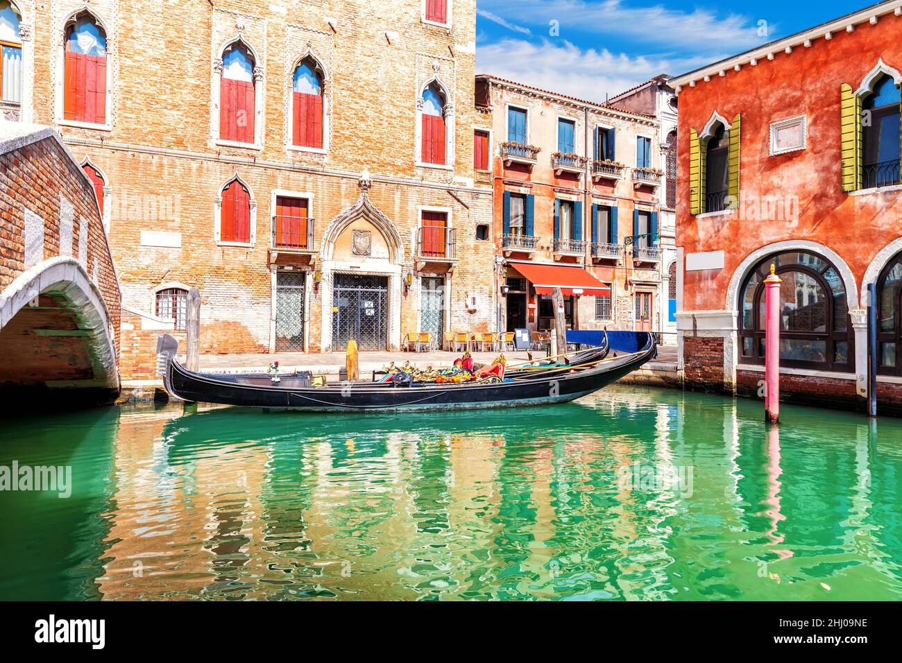 Tradizionale gondola vicino al ponte vicino al tipico palazzo di Venezia Foto Stock