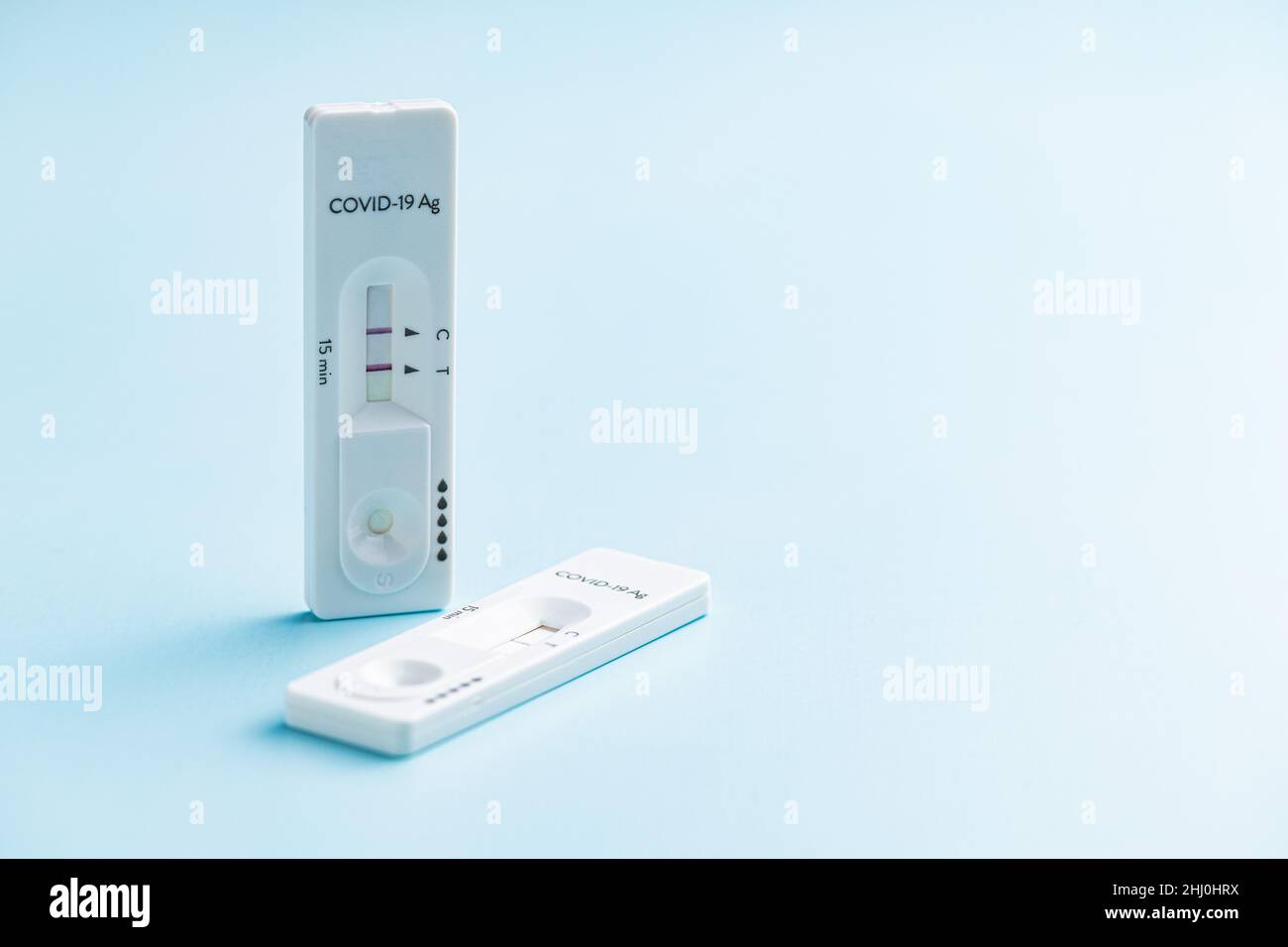 Test positivo dell'antigene Covid-19. Test rapido dell'antigene del coronavirus su sfondo blu. Foto Stock