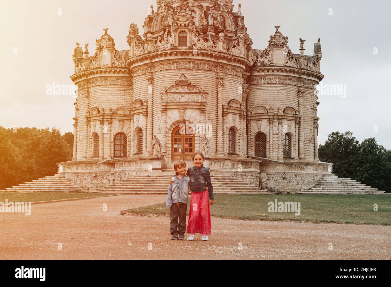 Mosca, Dubrovitsy 06.29.2021 due bambini felici fratelli viaggiatori sullo sfondo dell'esterno della chiesa ortodossa tempio di architetto gotico Foto Stock