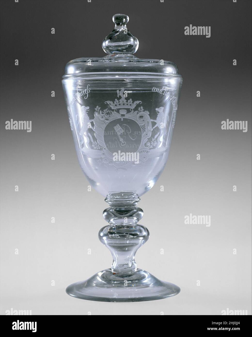Calice coperto 1788 New Bremen Glass Manufactory il vetraio tedesco John Frederick Amelung (1741/2–1798) aprì una serra nel Maryland occidentale nel 1787, rispondendo al desiderio americano di indipendenza economica dalla Gran Bretagna e alla necessità di sviluppare la produzione domestica. Nel giro di pochi anni, stava producendo una varietà di vetri per finestre, bottiglie e stoviglie nella sua fabbrica di New Bremen. Alcuni dei prodotti di Amelung presentano un'elaborata decorazione incisa in stile germanico. Questo esempio è firmato dalla fabbrica ed è il primo esempio datato noto. Inciso con le braccia di Brema, Germania, e Th Foto Stock