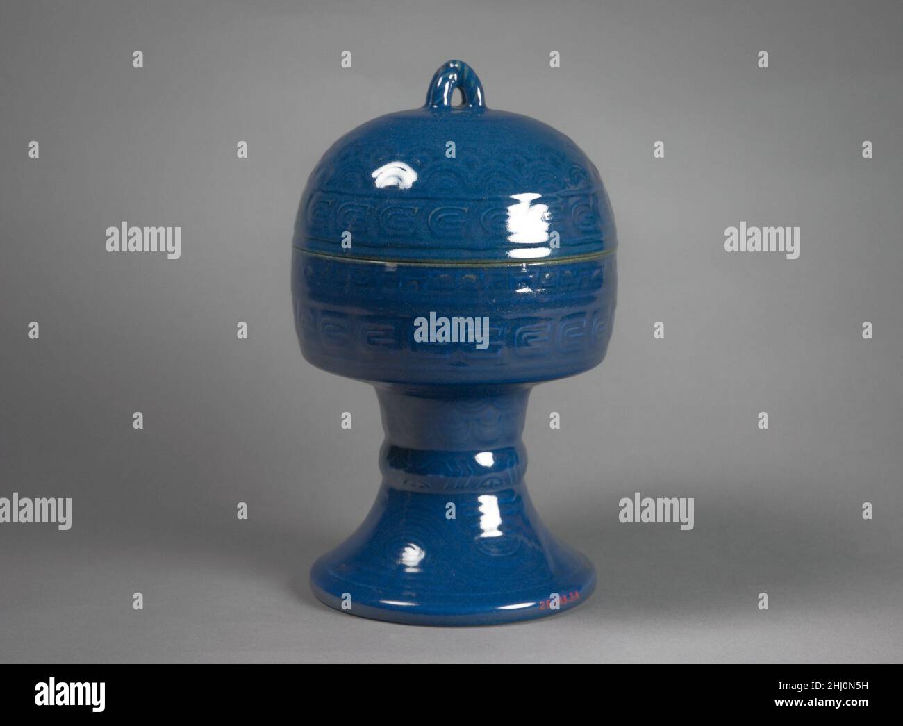 Vascello per l'offerta rituale (Dou) Cina questi vascelli (25.143.1–.3) sono stati usati nei rituali di stato tenuti nel primo mese lunare dell'anno, durante il quale l'imperatore ha fatto offerte al cielo all'altare per la raccolta abbondante (Qigutan), parte del Tempio del Cielo a Pechino. Nella forma e nella decorazione, questi vasi in ceramica, una gui e due dou, sono modellati su recipienti di grano di bronzo della dinastia orientale Zhou (770–256 a.C.), che avrebbero fatto parte di un più grande insieme di oggetti, impiegati in offerte rituali, che includevano contenitori per vino e carne. In tempi successivi, la ceramica prese il posto di bron Foto Stock