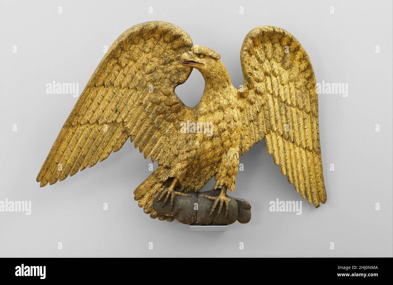 Figura di un'aquila 1800–1830 americana l'aquila calva americana fu adottata dal Congresso degli Stati Uniti per il sigillo nazionale nel 1782. Divenne presto il più popolare tra i motivi decorativi patriottici. Questa aquila intagliata e dorata, con le sue ali orgogliosamente sparse, è posta su una base rocklike. Uno dei più grandi del suo tipo, forse è stato il lavoro di un carvatore di figureheads di nave; tuttavia, non sembra essere stato utilizzato come ornamento di una nave o collocato all'esterno di un edificio, in quanto non mostra segni di intemperie.. Figura di un'aquila 10025 Foto Stock
