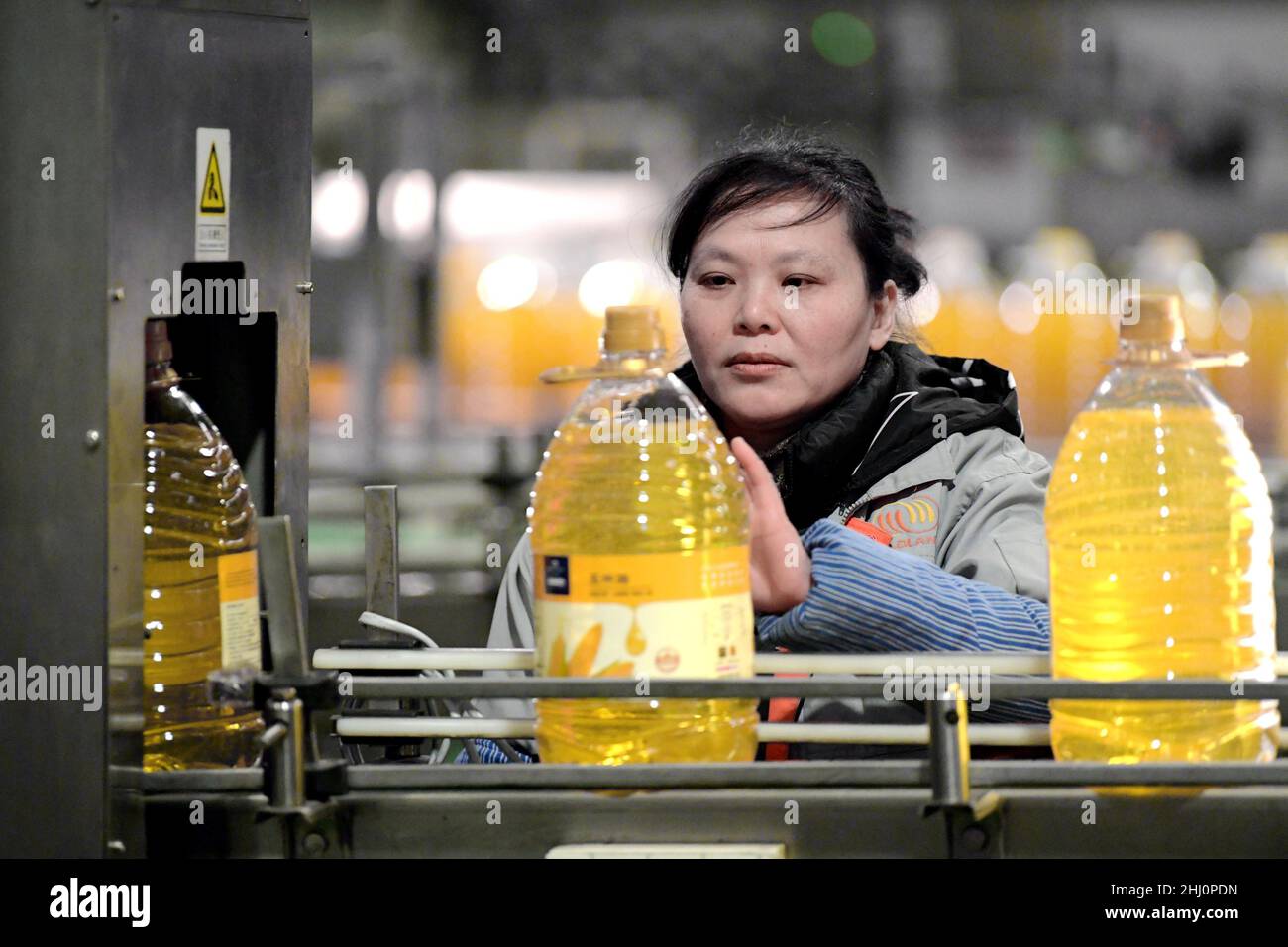 HAI'AN, CINA - 26 GENNAIO 2022 - un operaio lavora in una linea di produzione di riempimento di olio da cucina a Hai 'an, provincia di Jiangsu della Cina orientale, 26 gennaio 2022. Foto Stock