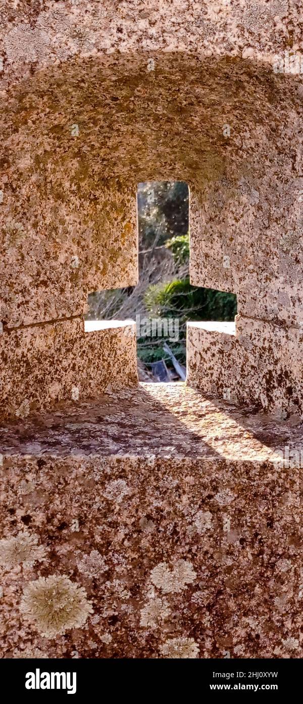 Finestra del castello a forma di croce rovesciata per difendere il tiro delle frecce Foto Stock