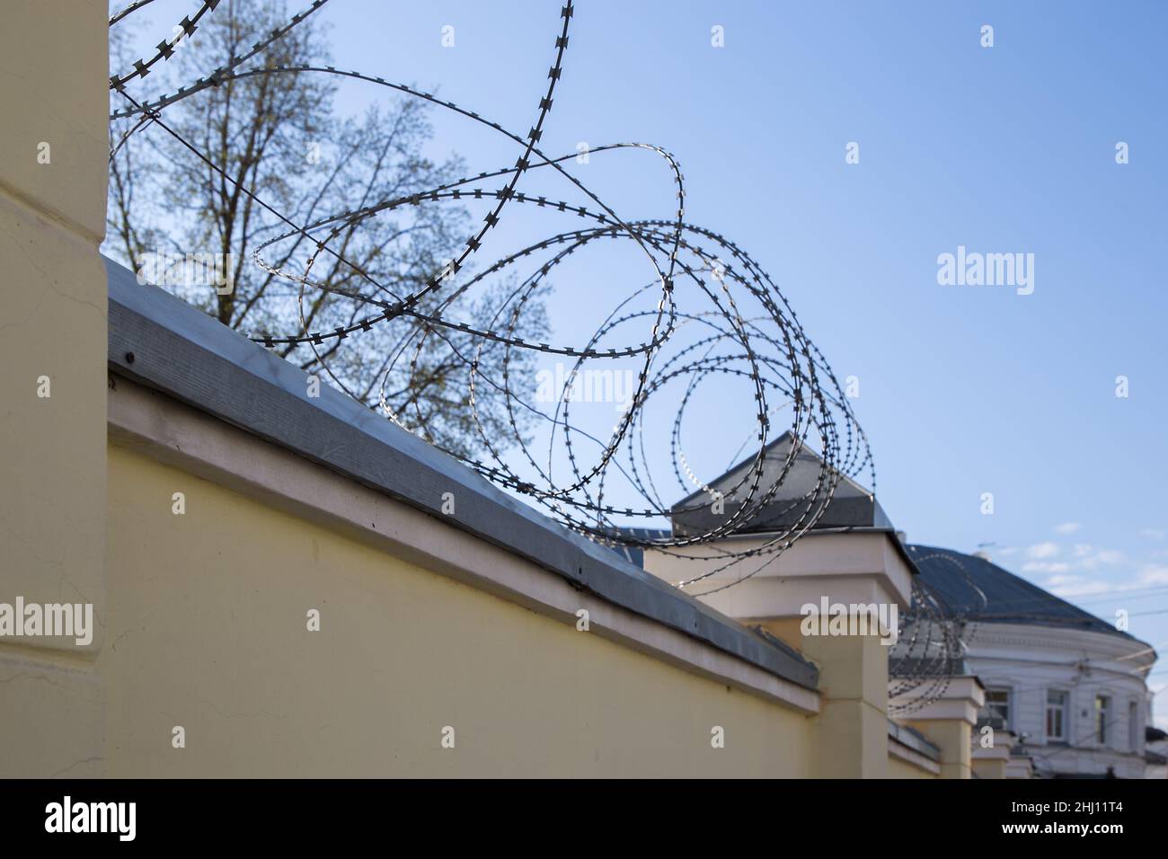 Recinzione di strutture sicure. Filo spinato sulla recinzione della struttura sicura. Foto Stock