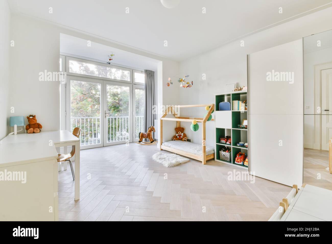 Adorabile camera per bambini con pareti bianche e pavimento in parquet bianco Foto Stock