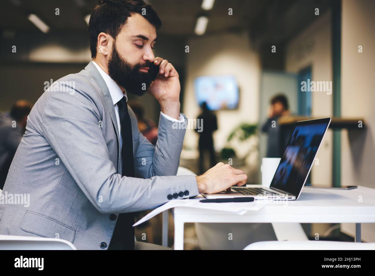 Responsabile attento che parla sullo smartphone in ufficio Foto Stock